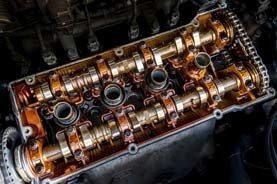 Nahaufnahme vom Kolbenblock und Kettengetriebe des Zylinderkopfs im Automotor.