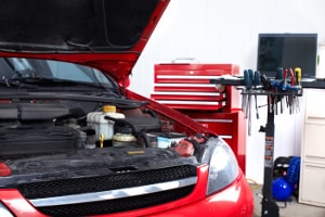 Ein roter Chevrolet bei der Reparatur in einer Werkstatt