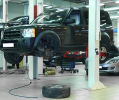 Schwarzer Land Rover wird in einer Werkstatt repariert