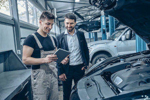 Mechaniker zeigt dem Kunden den gemachten Service an einem Mitsubishi-Modell