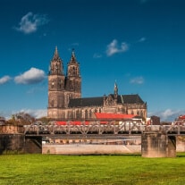 Seitliche Ansicht des Magdeburger Dom bei Tag und blauem Himmel als Hintergrund.