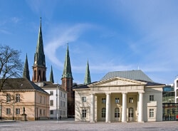 Bild der Altstadt von Oldenburg. Im Hintergrund ist eine Kirche zu sehen und der blaue Himmel.