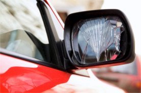 Der kaputte rechte Außenspiegel bei einem roten VW Golf