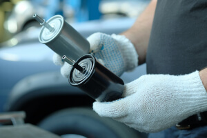 Mechaniker tauscht Benzinfilter eines Autos aus
