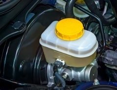 Nahaufnahme des Bremsflüssigkeitsbehälters und Bremskraftverstärkers im Motor eines Autos