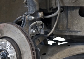 Nahaufnahme der durchgerosteten Bremsleitungen, die zu reparieren sind
