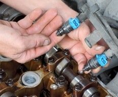 Fachmann prüft die Einspritzdüsen im Motor eines Autos