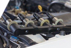 Kfz-Mechaniker wechselt die Einspritzdüsen mit Neuteil eines Autos