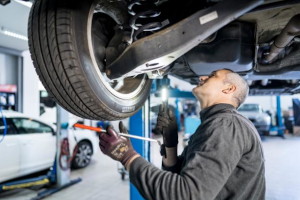 Machaniker beim Wechsel der Fahrwerksfedern am Auto