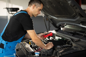 Mechaniker prüft die Glühkerze in einer Werkstatt