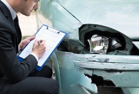 Kfz-Sachverständige beim Schadengutachten eines Autos mit Frontschaden