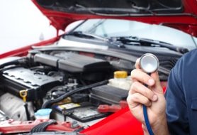 Konzept der Inspektion für den Peugeot: Fachamnn mit dem Stethoskop in der Hand vor einem roten Auto mit der geöffneten Motorhaube