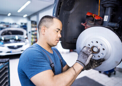 Mechaniker prüft Bremse in der Werkstatt
